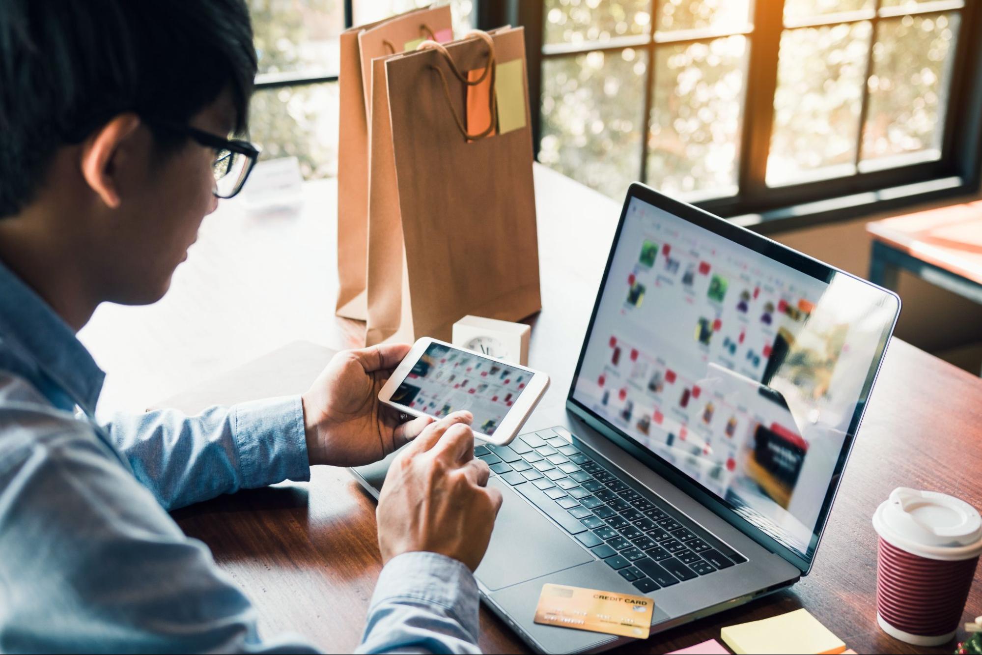 person using smartphone and laptop