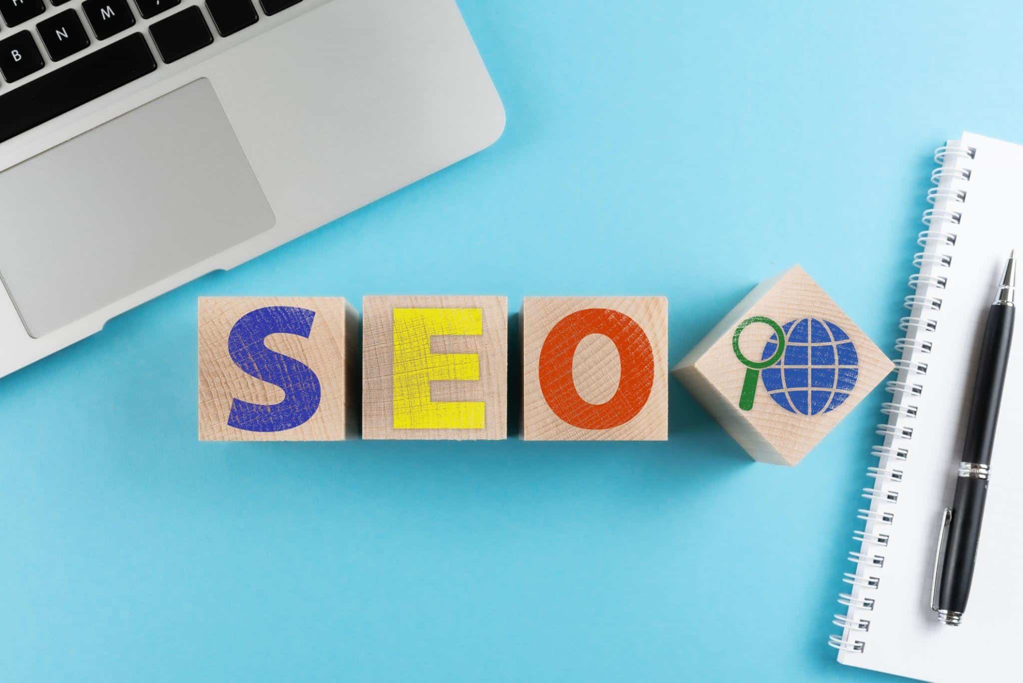 SEO blocks with laptop and notebook representing search engine optimization workspace